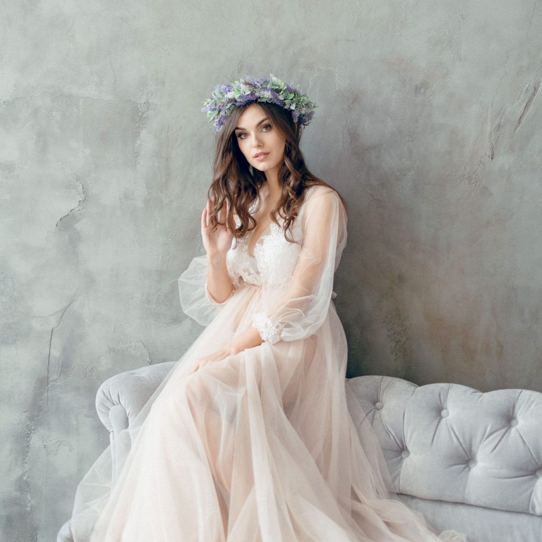 A girl in a beige peignoir, with a wreath of flowers on her head